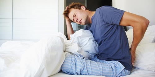 Чому болить спина після сну: причина, що робити і як лікувати